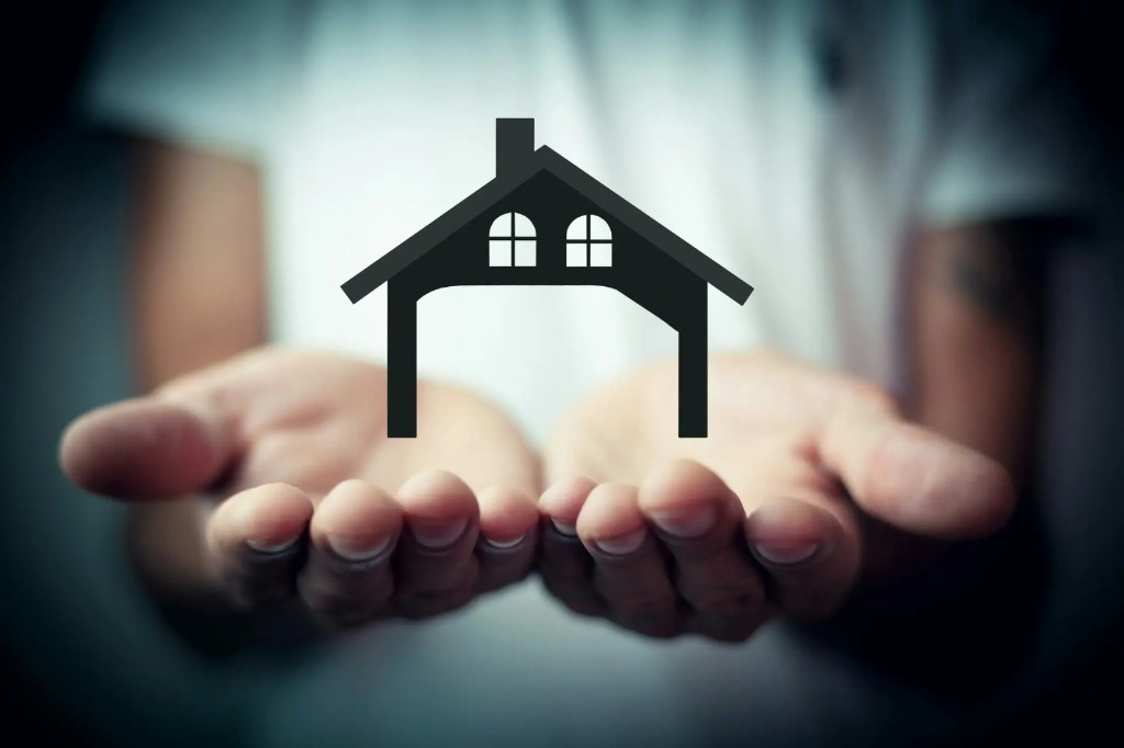 Hands protecting house model